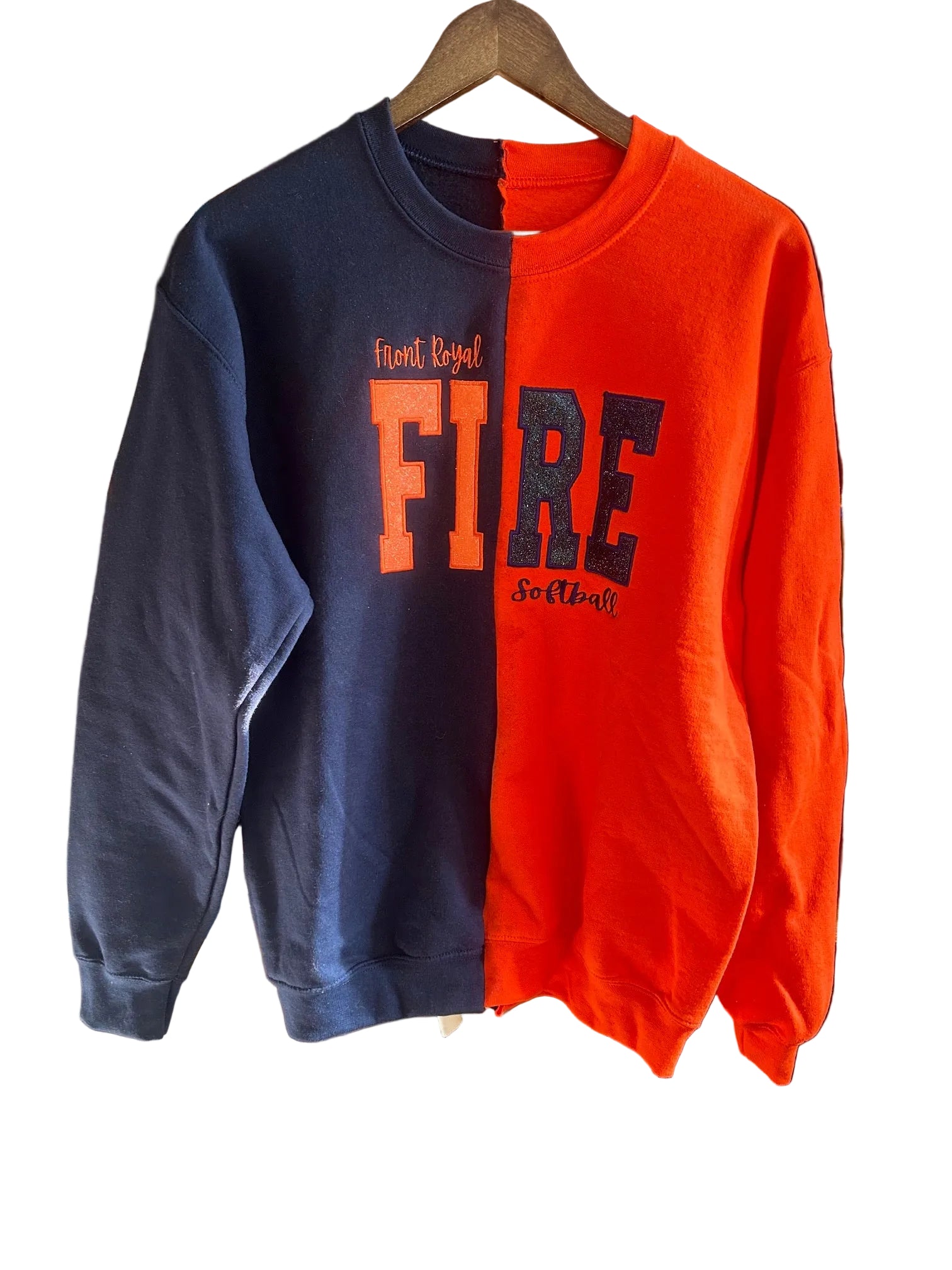 Orange and navy sweatshirt with 'FIRE' text on a wooden shelf.
